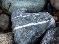 Herzförmiger schwarzer Stein mit zwei weißen Querbinden